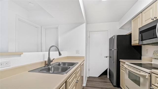 kitchen with cream cabinets, sink, dark wood-type flooring, and white appliances