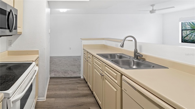 kitchen featuring sink, dishwasher, white electric range, dark hardwood / wood-style floors, and cream cabinets