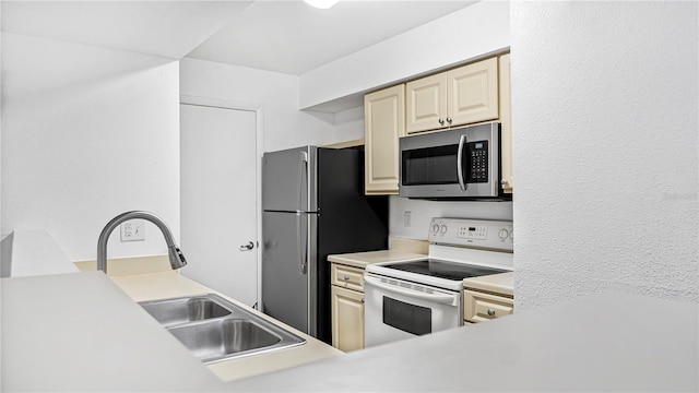 kitchen featuring appliances with stainless steel finishes, sink, and cream cabinets