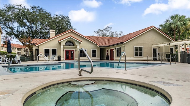 view of swimming pool with an in ground hot tub, french doors, and a patio