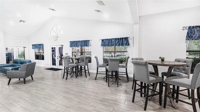 dining room with french doors and a towering ceiling