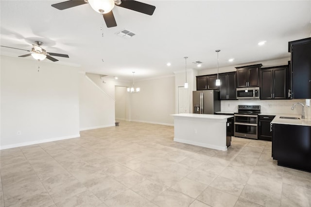 kitchen featuring ceiling fan with notable chandelier, sink, appliances with stainless steel finishes, decorative light fixtures, and a kitchen island