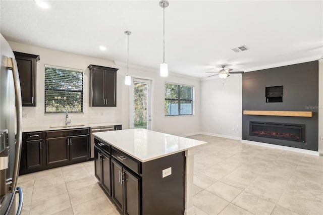 kitchen with pendant lighting, a center island, sink, stainless steel refrigerator with ice dispenser, and ceiling fan