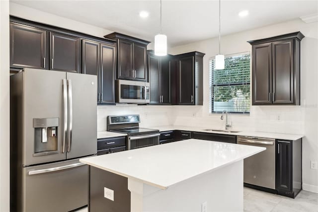 kitchen featuring dark brown cabinetry, sink, hanging light fixtures, a kitchen island, and appliances with stainless steel finishes