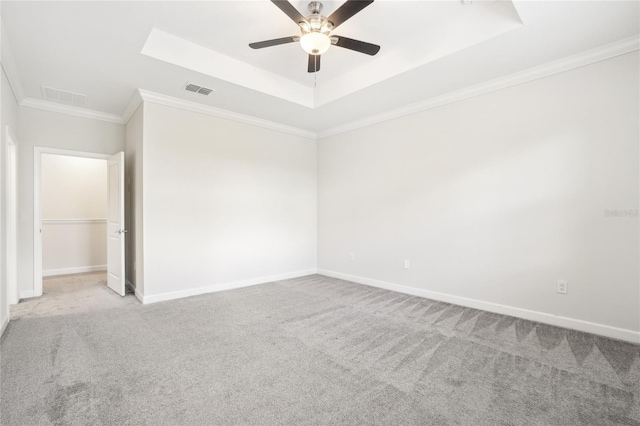 spare room with light carpet, a tray ceiling, ceiling fan, and crown molding