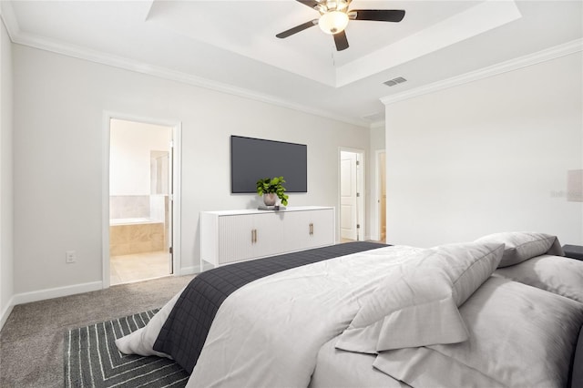 bedroom featuring carpet, ornamental molding, a tray ceiling, ceiling fan, and connected bathroom