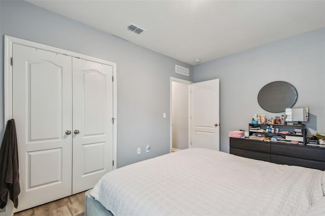 bedroom with light wood-type flooring and a closet