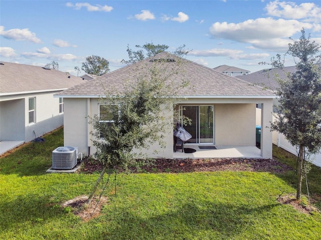 rear view of house featuring central air condition unit, a patio area, and a yard