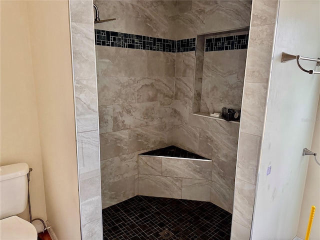 bathroom with tiled shower and toilet