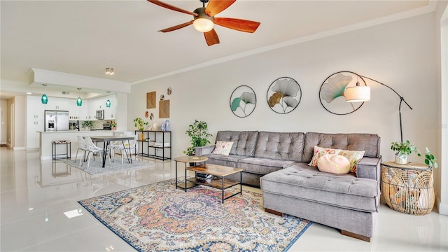 tiled living room featuring ceiling fan and ornamental molding