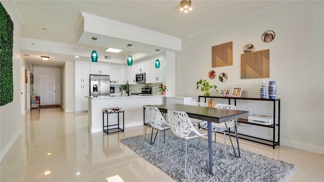 dining space with a tray ceiling, crown molding, baseboards, and light tile patterned floors