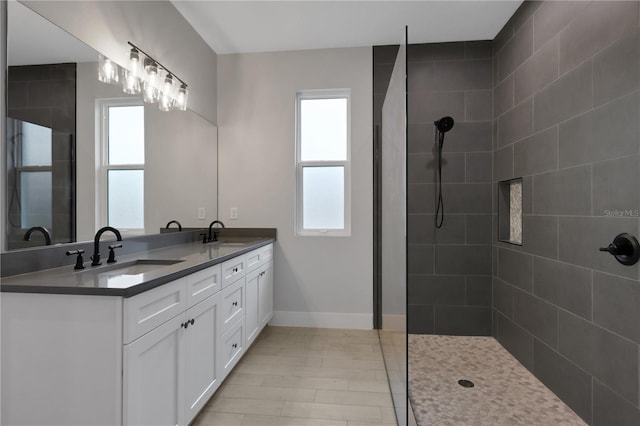 bathroom with tiled shower and vanity