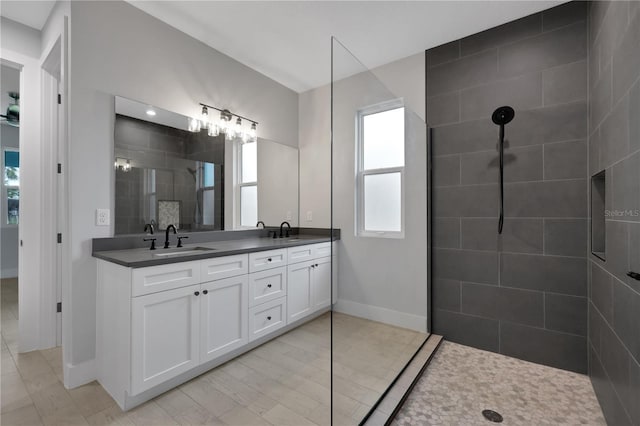 bathroom with vanity and a tile shower