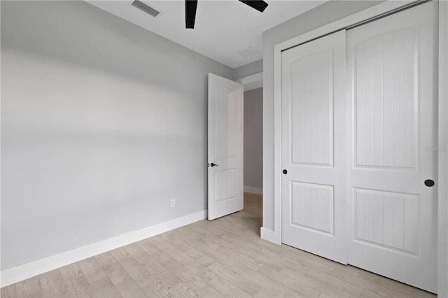 unfurnished bedroom featuring ceiling fan, light hardwood / wood-style flooring, and a closet