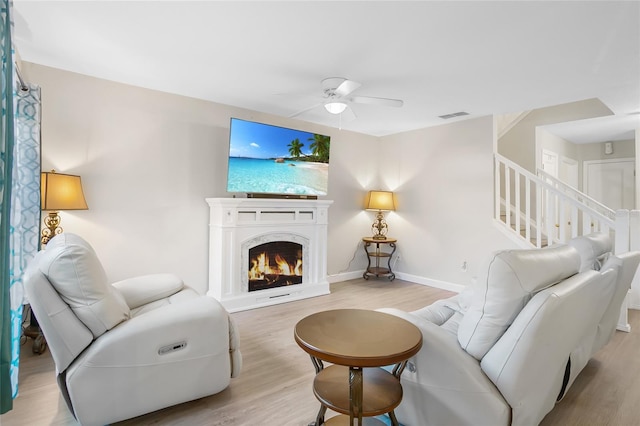 living room with ceiling fan and light hardwood / wood-style floors