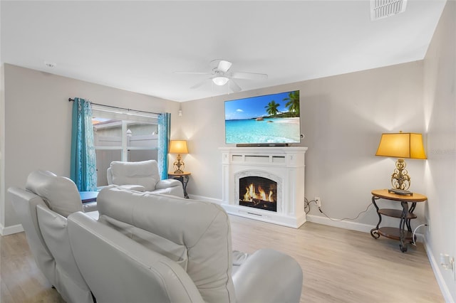 living room with ceiling fan and light hardwood / wood-style flooring