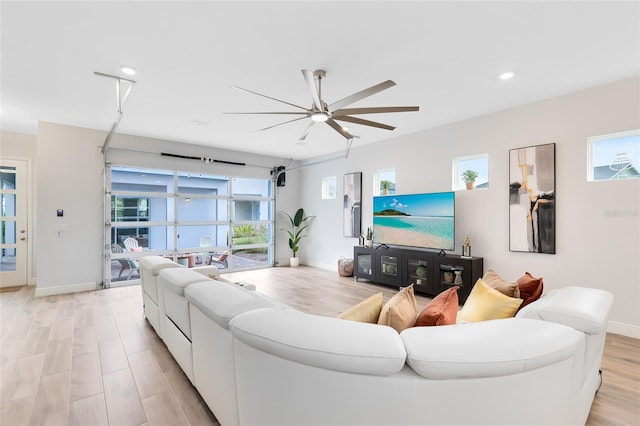 living room with ceiling fan and light hardwood / wood-style floors