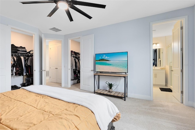 carpeted bedroom with ceiling fan and ensuite bathroom