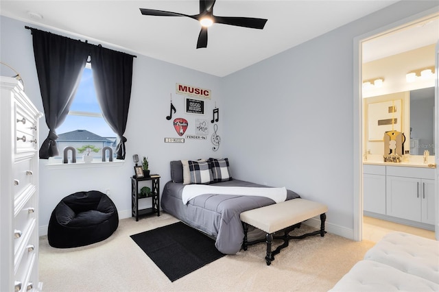 carpeted bedroom with ceiling fan, ensuite bath, and sink