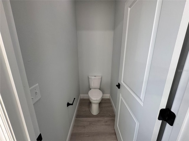 bathroom with hardwood / wood-style floors and toilet