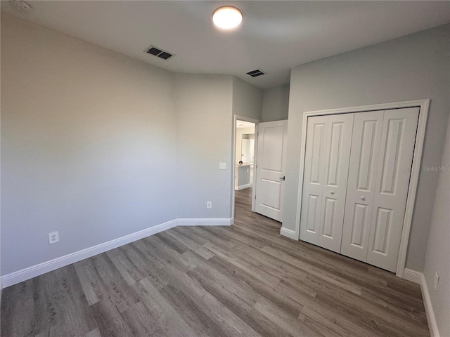 unfurnished bedroom featuring a closet and light hardwood / wood-style flooring