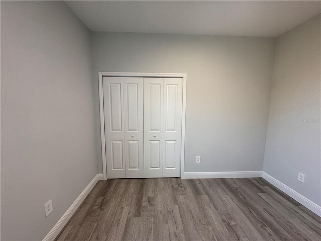 unfurnished bedroom with hardwood / wood-style flooring and a closet