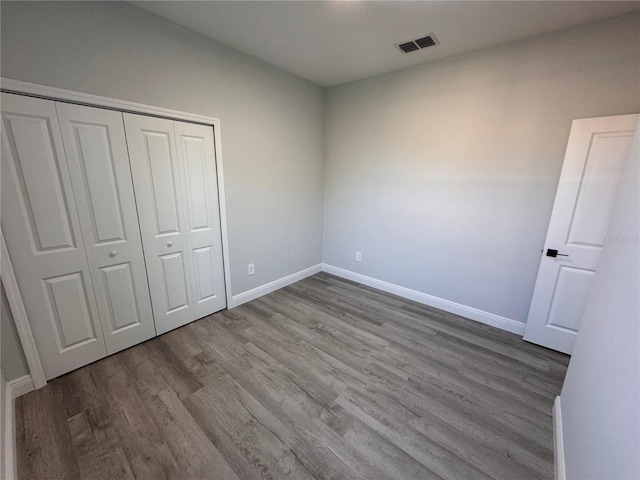 unfurnished bedroom with light wood-type flooring and a closet