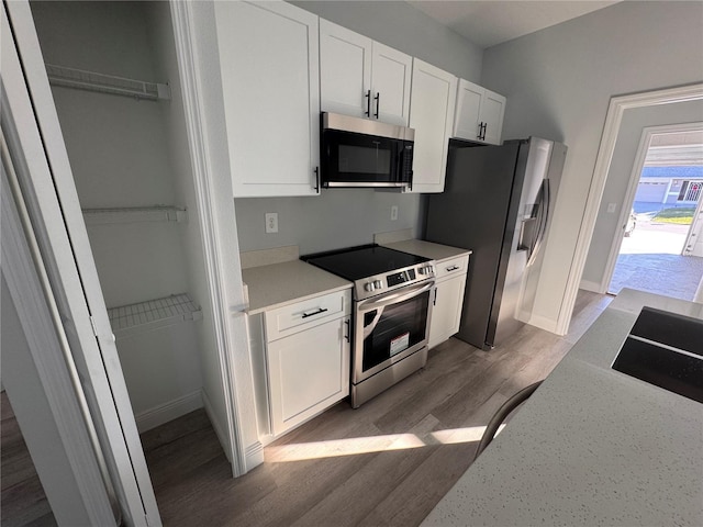 kitchen with white cabinetry, dark hardwood / wood-style floors, and appliances with stainless steel finishes