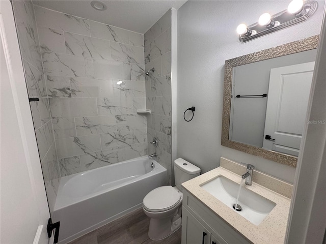 full bathroom featuring vanity, hardwood / wood-style flooring, toilet, and tiled shower / bath