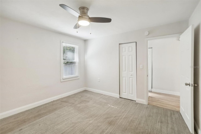 unfurnished bedroom featuring ceiling fan, light colored carpet, and a closet