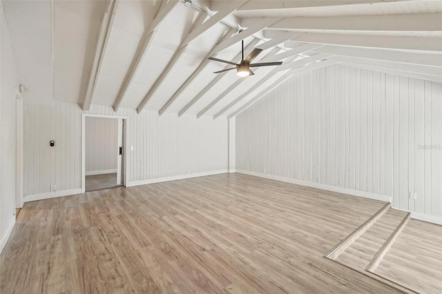 additional living space with ceiling fan, vaulted ceiling with beams, light hardwood / wood-style floors, and wooden walls