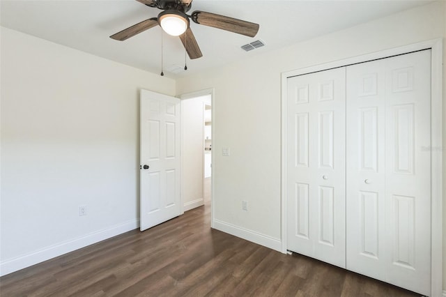 unfurnished bedroom with ceiling fan, dark hardwood / wood-style floors, and a closet