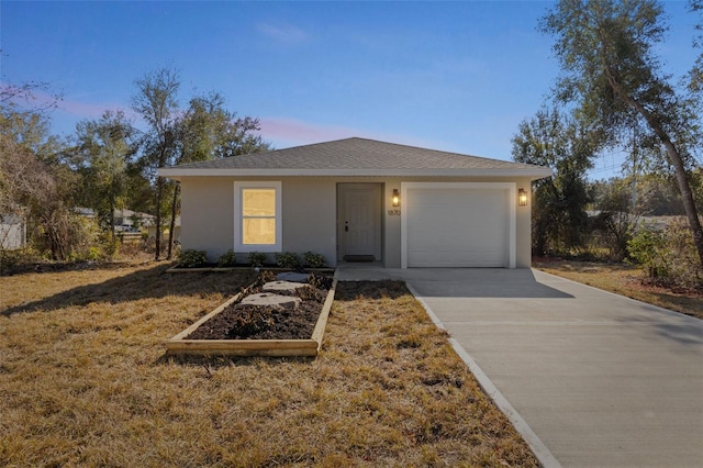 view of front of home with a garage and a lawn