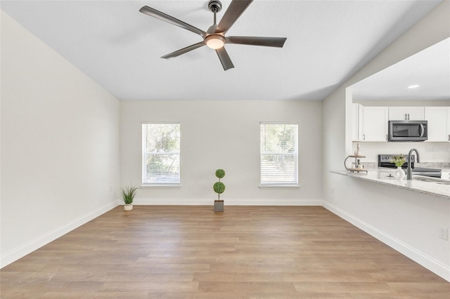 unfurnished living room with ceiling fan, lofted ceiling, and light hardwood / wood-style floors