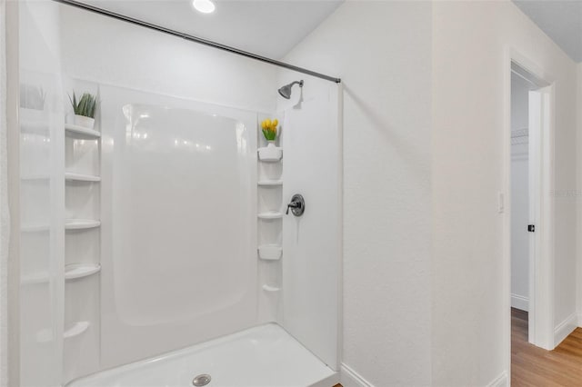 bathroom with wood-type flooring and walk in shower