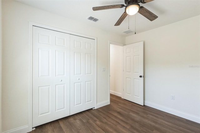 unfurnished bedroom featuring dark wood-type flooring, ceiling fan, and a closet