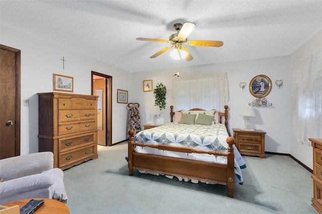 bedroom with ceiling fan, light colored carpet, and a textured ceiling