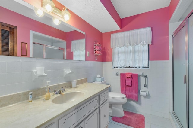 bathroom featuring walk in shower, a textured ceiling, vanity, tile walls, and toilet