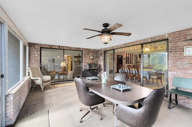 office space featuring carpet flooring, a textured ceiling, ceiling fan, and brick wall