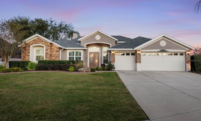 ranch-style house featuring a garage and a yard