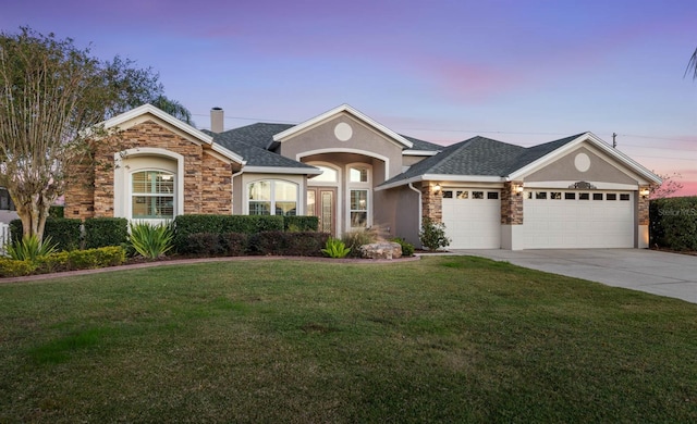 view of front of home with a lawn and a garage