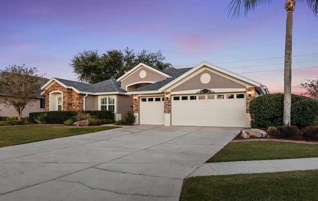 ranch-style home featuring a garage and a lawn