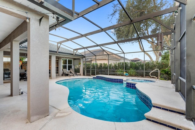 view of pool featuring an in ground hot tub, a patio area, and a lanai