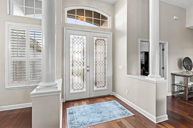 foyer entrance featuring decorative columns, french doors, and wood-type flooring