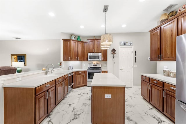 kitchen featuring sink, a center island, hanging light fixtures, kitchen peninsula, and appliances with stainless steel finishes