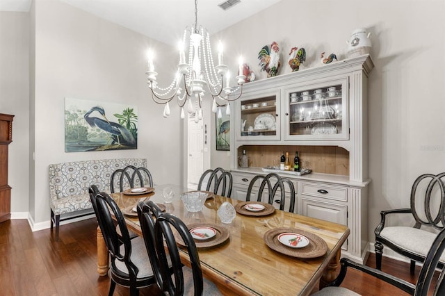 dining room with dark hardwood / wood-style floors and a chandelier