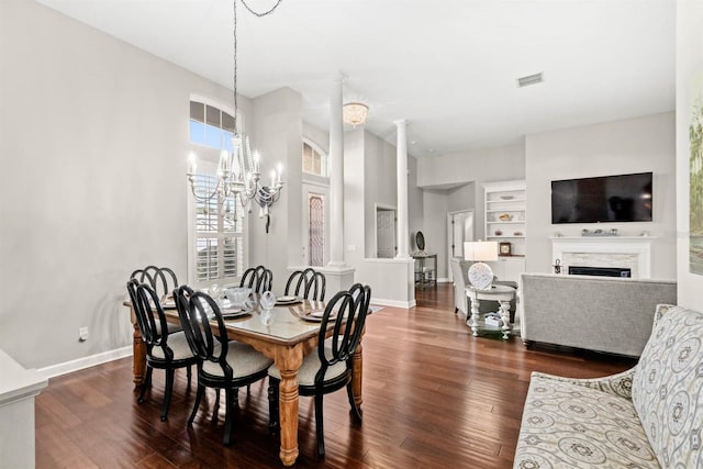 dining area with a chandelier, built in shelves, and dark wood-type flooring