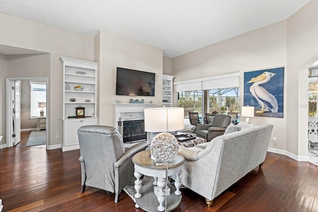 living room with dark hardwood / wood-style flooring and a fireplace