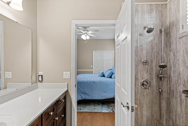 bathroom with ceiling fan, hardwood / wood-style floors, vanity, and walk in shower