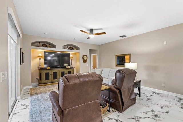 living room featuring built in shelves and ceiling fan